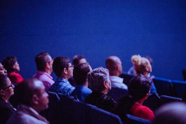 people sitting in theater chairs